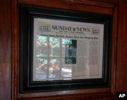 A framed newspaper clipping hangs near the entrance of the Stonewall Inn in New York, June 14, 2019, headlining the 1969 riots. Some of the coverage of rioting was a source of fury that led Stonewall to become a synonym for the fight for gay rights.