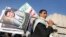FILE - A supporter carries posters depicting Houthi leader Abdel-Malek al-Houthi during a rally in Sana'a, Yemen, March 6, 2015.