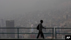 Un estudiante camina hacia la escuela en medio del humo de los incendios forestales en La Paz, Bolivia, el lunes 9 de septiembre de 2024.