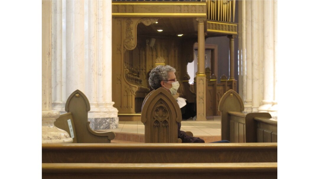 FILE - A congregant wears a face mask before mass at the Cathedral of St. Helena in Helena, Mont., April 26, 2020. Church services resumed in Montana as the state began to ease restrictions meant to stop the spread of the coronavirus.