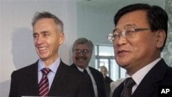 Associated Press President Tom Curley, left, and Korean Central News Agency President Kim Pyong Ho hold an Associated Press Pyongyang sign before hanging it on the door of the new AP bureau, situated inside the headquarters of the state-run KCNA in Pyongy