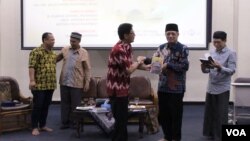 Agus Zainal Mubarok (dua kanan) menerima buku dari Jemaat Ahmadiyah Indonesia (JAI) usai diskusi di Aula Muhahari, Bandung, Senin, 13 Mei 2019. Sementara Ridwan Buton (kedua kiri) nampak berbincang dengan moderator. (Foto: Rio Tuasikal/VOA)