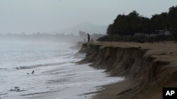 FILE - A man looks out at the Pacific ocean after heavy waves took away part of the beach in Pie de La Cuesta, on the outskirts of Acapulco, Guerrero state, Sept. 14, 2017. The weather service warned Sunday of intense storms ahead as Tropical Storm Bud intensifies. 