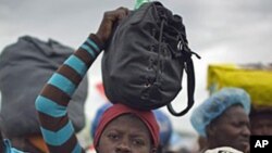 Haitians wait in line to be evacuated from the Corail-Cesselesse tent refugee camp before the arrival of tropical storm Tomas, 04 Nov 2010