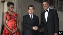 President Barack Obama and first lady Michelle Obama greet Chinese President Hu Jintao at the Grand Staircase as they arrive for a state dinner at the White House in Washington, Jan. 19, 2011. 