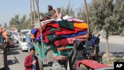 Des familles afghanes quittent leurs maisons après les combats entre l'armée afghane et les insurgés talibans dans la province de Helmand, au sud de l'Afghanistan, le 13 octobre 2020.