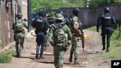 Soldados y policías llegan al área de la zona en la que cuerpos yacen en el piso en Culiacán, en el estado de Sinaloa, México, el martes 17 de septiembre de 2024. 