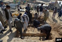 FILE - Shi'ite mourners and relatives dig graves the day after multiple blasts hit outside a girls' school, during the burial at a desolate hilltop cemetery in Dasht-e-Barchi on the outskirts of Kabul, May 9, 2021.