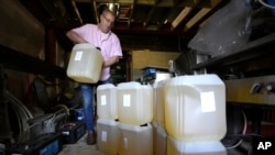 Harry Niazi carries a container of sunflower oil out of storage at Olleys Fish Experience in London, England April 21, 2022. Cooking oil prices have been rising since the pandemic began and Russia's war in Ukraine has sent costs spiraling. (AP Photo/Kirsty Wigglesworth)