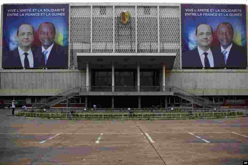 Giant posters featuring French President Francois Hollande and his Guinean counterpart Alpha Conde are displayed on the facade of the People's Palace in Conakry, Guinea, Wednesday, Nov. 26, 2014. 