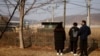 资料照：2021年2月12日，在韩国农历新年到来之际，一名脱北者和他的孩子们站在京畿道坡州市非军事区附近的铁丝网前。（路透社）