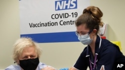 Britain's Prime Minister Boris Johnson receives the first dose of the AstraZeneca vaccine administered by nurse and Clinical Pod Lead, Lily Harrington at St.Thomas' Hospital in London, March 19, 2021.