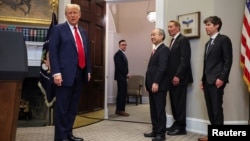 U.S. President Donald Trump, left, is seen with Oracle co-founder Larry Ellison, SoftBank CEO Masayoshi Son, and OpenAI CEO Sam Altman after delivering remarks on AI infrastructure, in the Roosevelt room at White House in Washington, Jan. 21, 2025.