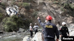 Rescue workers and police officers attend the place where a bus crashed, in Matucana, Peru, August 31, 2021. 