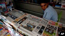 FILE - A vendor sits in his newspaper stand in Buenos Aires, Argentina.