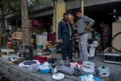 Comerciantes afganos exhiben artículos domésticos usados para vender en un área de mercado en Kabul el 25 de agosto de 2021.