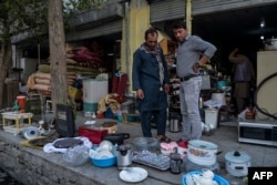 Comerciantes afganos exhiben artículos domésticos usados para vender en un área de mercado en Kabul el 25 de agosto de 2021.