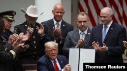 El presidente Trump muestra su firma en el decreto de reforma policial, durante el acto de presentación celebrado en la Casa Blanca.