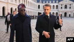 Nigerian President Bola Tinubu and French President Emmanuel Macron review an honor guard during a ceremony in Paris on Nov. 28, 2024, as part of Tinubu's state visit to France.