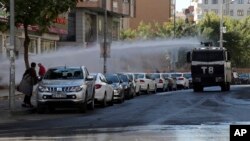 Police use water cannons against pro-Kurdish Peoples' Democratic Party members as they protest the detention of Co-mayors Gultan Kisanak and Firat Anli, in Diyarbakir, Turkey, Oct. 26, 2016.