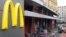 People walk in front of a closed McDonald's restaurant, the first to be opened in the Soviet Union in 1990, in Moscow, August 21, 2014. 