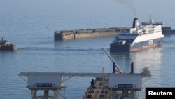 FILE - A ferry is seen maneuvering as it arrives from France at the Port of Dover, Britain, Feb. 14, 2019. 