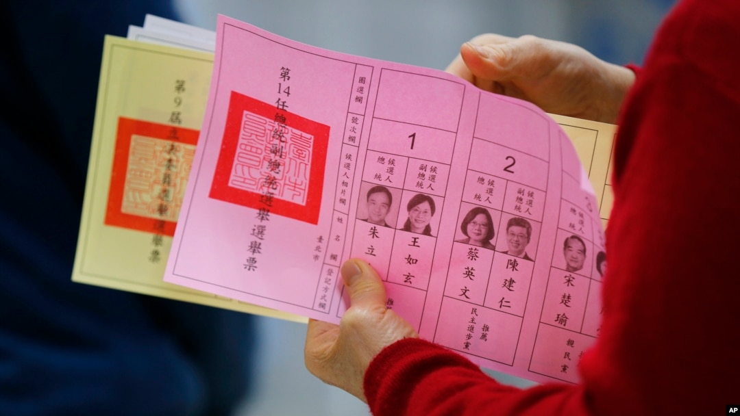 一位台灣民眾2016年1月16日在台北一投票站準備填寫手中的選票