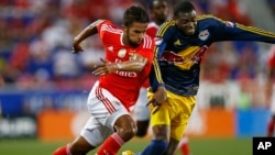 Le milieu Marocain Mehdi Carcela-Gonzalez de SL Benfica, à gauche, dans un duel avec le défenseur de Red Bulls de New York Anthony Wallace lors d’un match de la coupe des Champions à Harrison, N.J., 26 juillet 2015. 