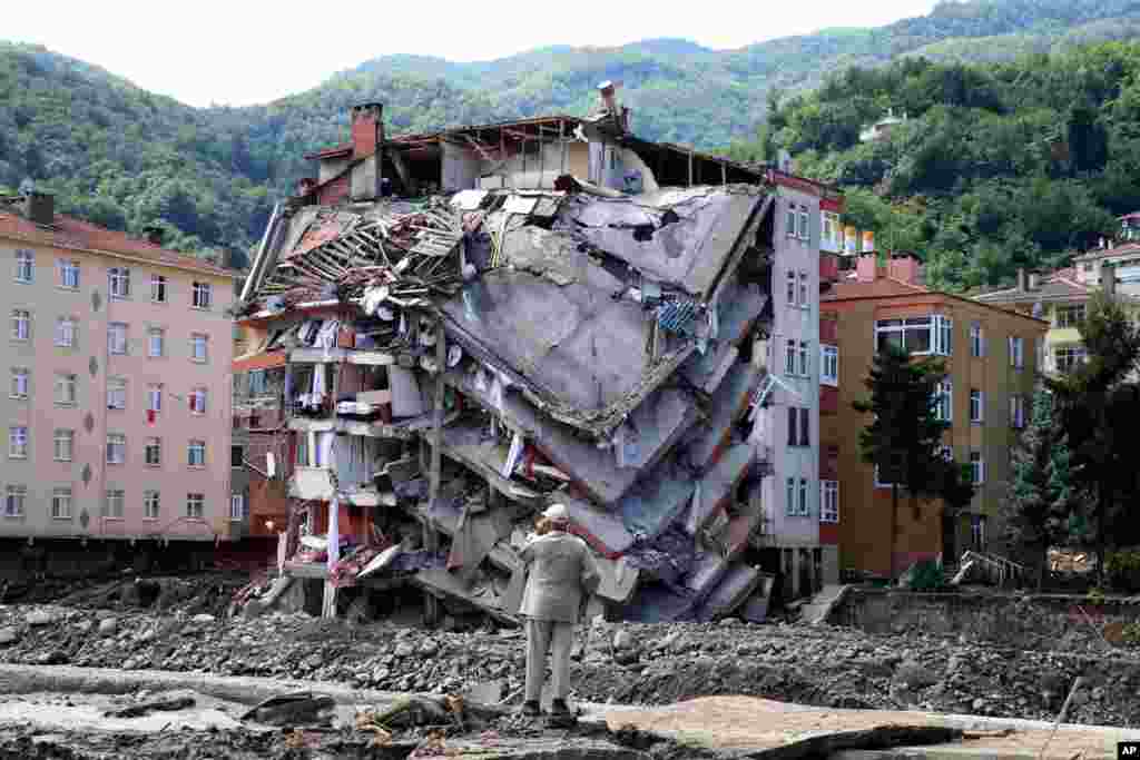 A man looks at destroyed building, in Bozkurt town of Kastamonu province, Turkey, Aug. 14, 2021. The death toll from severe floods and mudslides in coastal Turkey has climbed to at least 44, the country's emergency and disaster agency said.