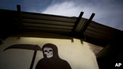 FILE - A mural of La Santa Muerte, or Saint Death, decorates the wall of a community center in Colonias, Michoacan state, Mexico, where vigilantes met with families after a shooting, Jan. 8, 2015.