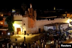 مردم در نزدیکی یک ساختمان آسیب‌دیده در شهر مراکش حضور یافته‌اند
