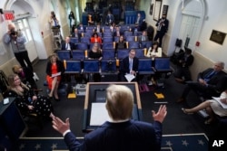 Reporters are seen complying with social distancing norms as President Donald Trump speaks about the coronavirus in the James Brady Press Briefing Room at the White House, April 13, 2020, in Washington.