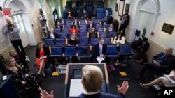 Reporters are seen complying with social distancing norms as President Donald Trump speaks about the coronavirus in the James Brady Press Briefing Room at the White House, April 13, 2020, in Washington. 