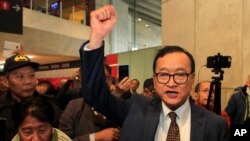 Cambodian opposition politician Sam Rainsy clenches his fist as he attempts to return to his homeland, Nov. 7, 2019, at Charles de Gaulle airport, north of Paris.