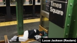 Seorang tunawisma di New York, tengah beristirahat di stasiun kereta api (subway) yang relatif sepi di tengah pandemi Covid-19, 13 April 2020. (Foto: dok).