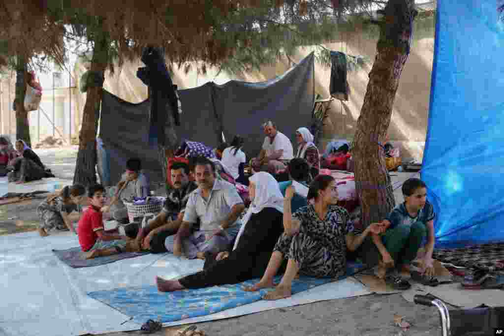 Displaced Iraqis from the Yazidi community gather at a park near the Turkey-Iraq border at the Ibrahim al-Khalil crossing, as they try to cross to Turkey, in Zakho, 475 km northwest of Baghdad, Aug. 15, 2014.
