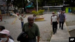 ARCHIVO - Personas mayores se dirigen a un comedor de beneficencia para recibir una comida gratis que se ofrece dos veces por semana en el barrio La Vega de Caracas, Venezuela. (Foto AP/Ariana Cubillos, Archivo)