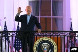 El presidente de Estados Unidos, Joe Biden, saluda desde el Balcón Truman de la Casa Blanca cuando llega para ver el espectáculo de fuegos artificiales del Día de la Independencia en Washington, DC, el 4 de julio de 2024.