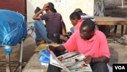 Un homme en pleine lecture de son journal à Westfield, à Banjul, en Gambie, le 7 juin 2017. (S.Christensen/VOA)