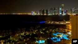 FILE - The skyline of Doha, Qatar, is seen at night from the St. Regis Hotel.