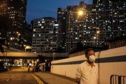 A man wears a face mask as a precautionary measure against COVID-19 as he walks along a street in Hong Kong on April 21, 2020.