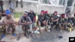 In this image taken from militant video released by the Islamic State group on Monday March 29, 2021, purporting to show fighters near the strategic north eastern Mozambique town of Palma.