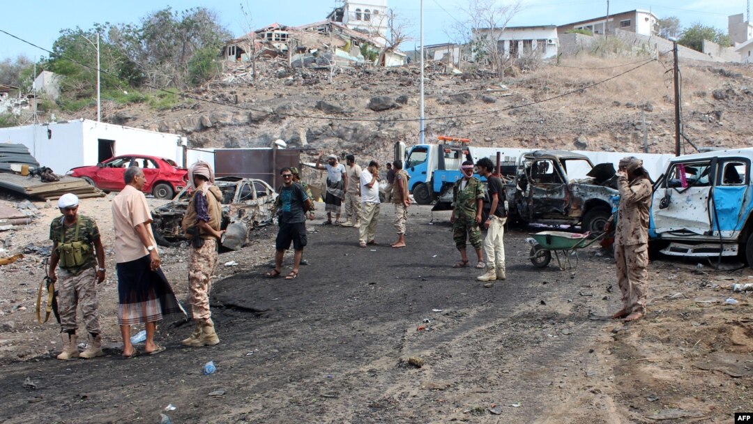Yemeni loyalist forces and onlookers gather at the scene of a suicide attack targeting the police chief in the base of the Saudi-backed government on April 28, 2016 in Yemen's second city Aden.