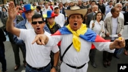 FILE - Opponents of government peace talks with FARC guerrillas shout slogans during a march in Bogota, Colombia, Dec. 13, 2014. 