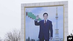 A woman walks past a board displaying a portrait of Turkmenistan's President Gurbanguly Berdimuhamedov in Ashgabat, February 10, 2012.