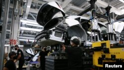 FILE - Workers marry the body structure with the battery pack and the front and rear sub frames as they assemble electric vehicles at the Lucid Motors plant in Casa Grande, Arizona, U.S. September 28, 2021. (REUTERS/Caitlin O'Hara/File Photo)