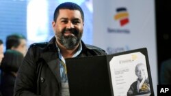 Esteban Felix, fotografer Associated Press asal Peru yang ditempatkan di Peru, menunjukkan penghargaan internasional "Gabriel García Márquez" untuk karya fotonya seusaia upacara penyerahan penghargaan di Medellin, Kolombia (20/11).