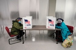 FILE - Two voters fill out ballots during early voting at the Cuyahoga County Board of Elections in Cleveland, Oct. 6, 2020. (AP)
