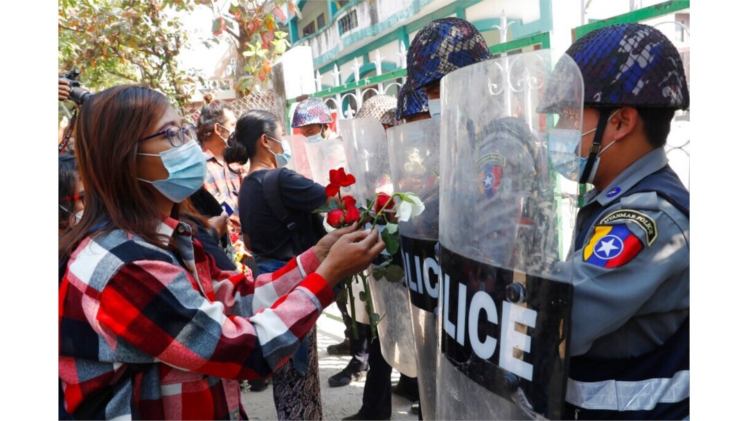 Supporters give roses to police while four arrested activists make a court appearance in Mandalay, Myanmar, Feb. 5, 2021.
