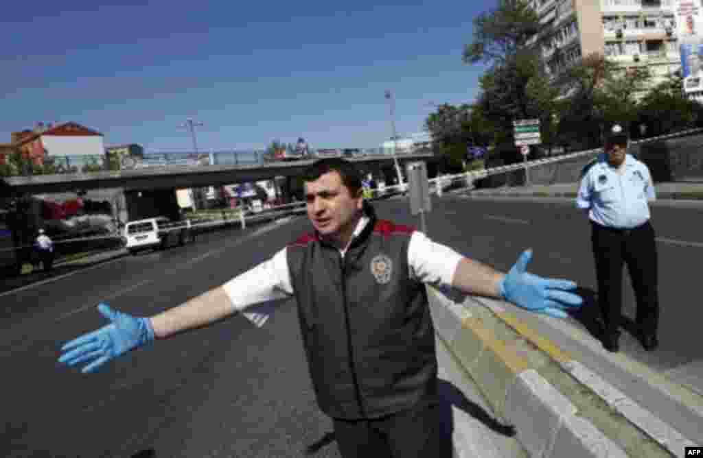 A police forensic officer asks the media to leave a blast scene in Istanbul May 26, 2011. A bicycle bomb wounded seven people including a police officer in Istanbul on Thursday, Istanbul's police chief Huseyin Capkin told reporters. He said none of the wo